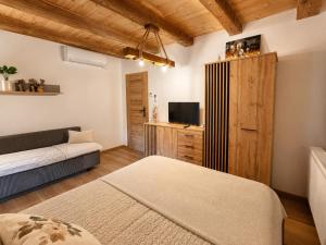 a room with a bed and a couch and a television at Farma Puchałowo in Puchałowo