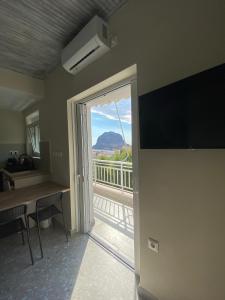 a room with a door open to a balcony with a view at Mu Caza Monemvasia in Monemvasia