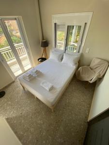 a large bed in a room with two windows at Mu Caza Monemvasia in Monemvasia