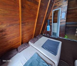 a bed in a room with a wooden wall at Cozzy Villa Hajeka in Palayangan