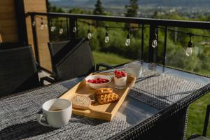 a table with a tray of food and cups of coffee at Elegant Condo - Balcony Pool & Stunning View in Baie-Saint-Paul +67 photos