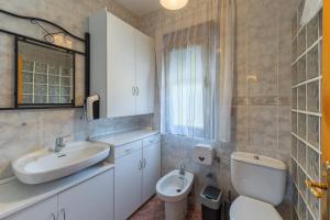 a bathroom with a sink and a toilet at Vivienda turística El Laurel in Valdemanco +23 photos