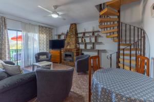 a living room with a couch and a staircase at Vivienda turística El Laurel in Valdemanco