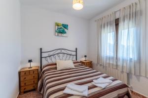 a bedroom with a bed and two night stands and a window at Vivienda turística El Laurel in Valdemanco