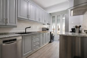 a kitchen with white cabinets and a sink at Palmeras Puerto Torrevieja in Torrevieja