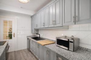 a white kitchen with a sink and a microwave at Palmeras Puerto Torrevieja in Torrevieja +11 photos