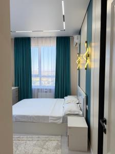 a bedroom with a bed and a large window at Улы Дала in Shymkent