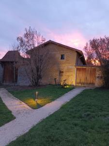 a house with a gravel road in front of it at La ferme de Berlioz in La Côte-Saint-André