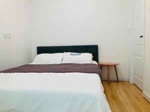 a bed in a white room with a table at Newly Renovated Japandi 1BR Near Shangri-La in Ulaanbaatar