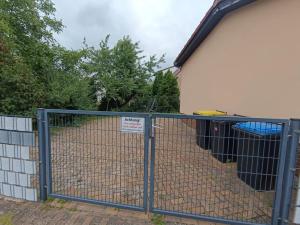a fence with a sign on it next to a house at NEU! Ferienhaus Schwedt in Schwedt +5 photos