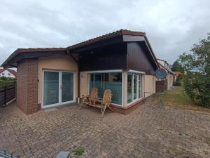 a small house with a patio with two chairs at NEU! Ferienhaus Schwedt in Schwedt