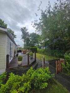 a wooden deck with potted plants on a house at Chalet Ankerplatz in Lauwersoog in Lauwersoog +9 photos