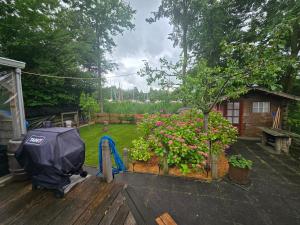 a garden with a blue umbrella and flowers on a deck at Chalet Ankerplatz in Lauwersoog in Lauwersoog
