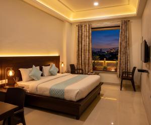 a bedroom with a bed and a window with a view at Jeenmount Heritage Boutique Hotel-JLN Marg in Jaipur