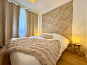 a bedroom with a bed with a blanket on it at Le Cocon Doré in Calais