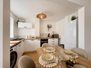 a kitchen with a table and chairs and a kitchen with a table and a dining at Le Cocon Doré in Calais +6 photos