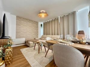 a living room with a dining table and a living room with a couch at Le Cocon Doré in Calais