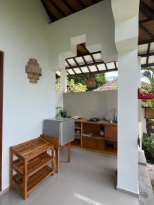 an open kitchen with white walls and wooden furniture at Anda Amed Villas & Spa in Amed