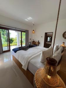 a bedroom with a large bed and a large window at Anda Amed Villas & Spa in Amed