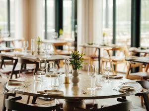 a group of tables with glasses and flowers on them at Eriksberg Hotel & Nature Reserve in Trensum
