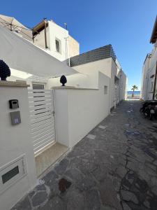 a white building with a gate and a driveway at Camilla Lipari House - Canneto in Lipari