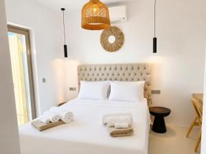 a bedroom with a white bed with towels on it at Lucevista Mykonos Villas in Fanari
