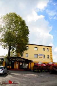 budynek z drzewem przed nim w obiekcie Restauracja i Noclegi Pod Sikorką w mieście Kobior