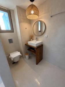 a bathroom with a sink and a toilet and a mirror at Lucevista Mykonos Villas in Fanari +44 photos