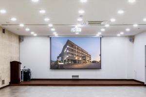a large projection screen in a room with a building at 씨뷰 호텔 in Naedo-dong