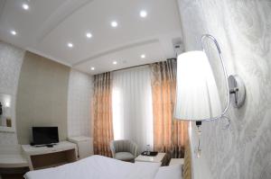 a hotel room with a bed and a desk and a lamp at Hotel Afrosiyob in Qarshi