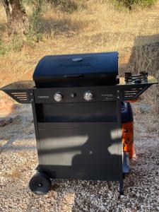 a black barbecue grill sitting on top of gravel at Finca la montaña roja in Almogía