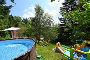 a backyard with a swimming pool and a playground at Wild House Szczyrk in Szczyrk