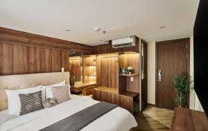a bedroom with a large bed and wooden walls at Centoria Hotel By Urban B in Ho Chi Minh City