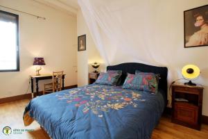 a bedroom with a bed with a blue comforter at la caquetoire in Les Églisottes-et-Chalaures +45 photos