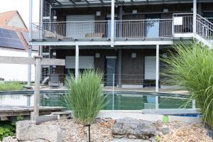 a building with a swimming pool and a balcony at Ferienwohnung Bodensee in Meßkirch