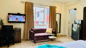 a living room with a couch and a tv at BluO Lake View Studio - NewTown - Terrace Garden in Kolkata