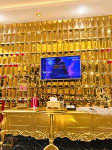 a room with a wall of gold bottles at Athena Hotel Huế in Hue