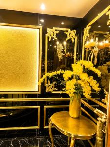 a vase of yellow flowers sitting on a table at Athena Hotel Huế in Hue