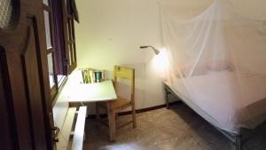 Private Holiday Apartment في تارافال: مكتب فيه مصباح وكرسي في الغرفة