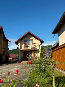 a house with a balcony on the side of it at Pensiunea Popan in Şieu