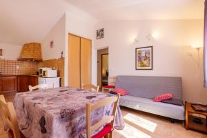 a living room with a table and a couch at Le Figuier - La Fontinelle in Bessas