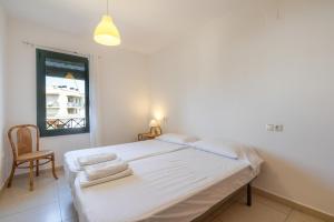 a bedroom with a bed with a chair and a window at Torredembarra in Torredembarra +18 photos