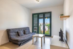 a living room with a couch and a tv at Torredembarra in Torredembarra