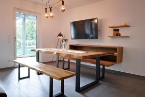 a dining room with a table and a tv at Ferienwohnung Bodensee in Meßkirch