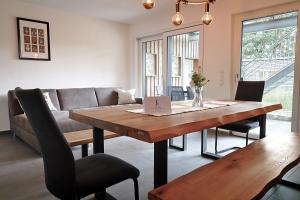 a living room with a wooden table and a couch at Ferienwohnung Bodensee in Meßkirch