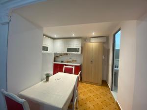 a kitchen with a white table and a table and chairs at The Two Princesses in Shirokë