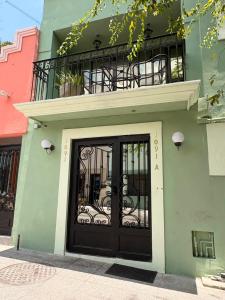 a building with a black door and a balcony at Barrio Inn Morelos in Monterrey