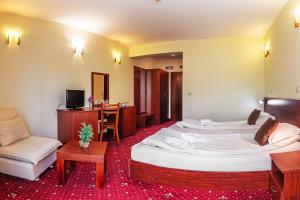 a hotel room with a large bed and a chair at Hotel Bojur & Bojurland Apartment Complex in Bansko +92 photos
