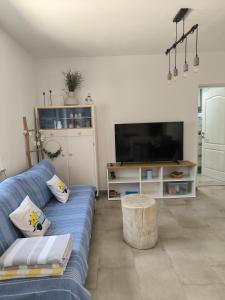 a living room with a blue couch and a tv at Villa Lando in Peruški