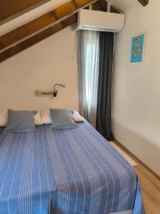 a blue bed in a room with a window at Villa Lando in Peruški